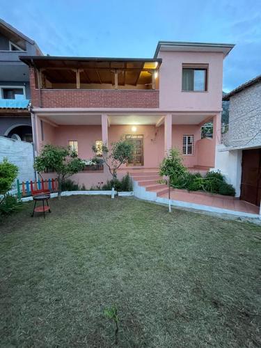 克鲁亚Vila 8 Kruje的粉红色的房子,前面有草坪
