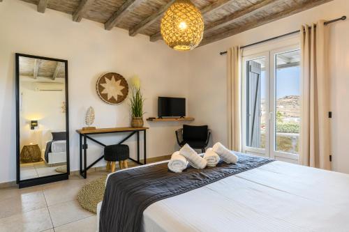 卡拉法蒂斯Aurora Mykonos Villas的一间卧室配有一张床、一张书桌和一个窗户。