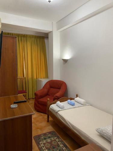 都拉斯~Villa Gloria~的一间卧室配有一张床和一张红色椅子