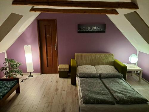 SokołowskoApartament Zielony Zakątek的一间卧室配有一张床和紫色的墙壁