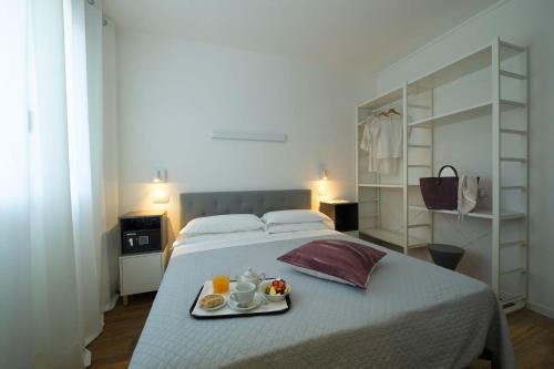 比比翁Nice Hotel Bibione的一间卧室配有一张床,上面放着一个食物托盘
