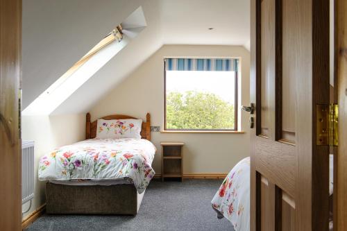 伦维尔Honeysuckle Cottage的一间小卧室,配有床和窗户