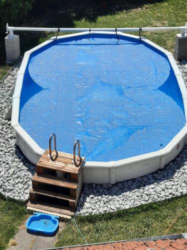 基尔维莱Au bonheur des hirondelles的一座蓝色的大游泳池,四周环绕着木板箱
