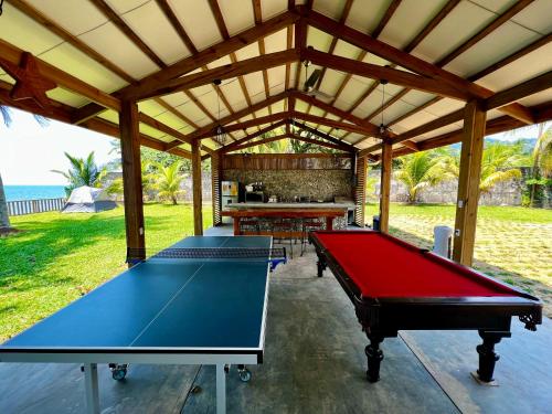 奥莫阿Sunset Hut Hostel的亭子里的乒乓球桌,有两张桌子