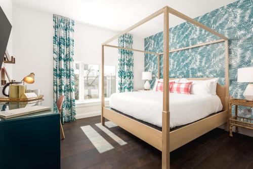 彭萨科拉Lily Hall的一间卧室配有天蓬床和蓝白色窗帘