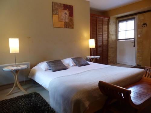 Saint-Germain-de-Belvès莱斯帮蒂尼斯住宿加早餐旅馆的卧室配有一张带两个枕头的大白色床