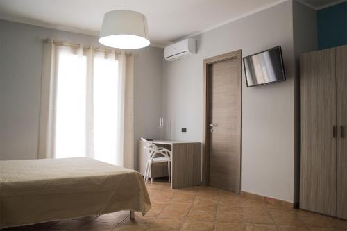兰佩杜萨Incanto Luxury Rooms的一间卧室配有一张床、一张书桌和一台电视