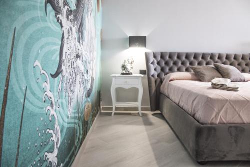兰佩杜萨Incanto Luxury Rooms的一间卧室配有一张床和一张带台灯的桌子