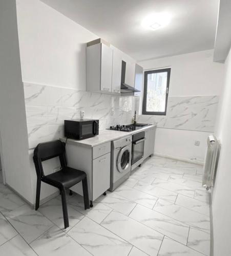 图尔恰City Center Apartment的厨房配有洗衣机和椅子
