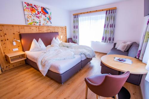 拉姆绍达赫斯坦贝格尔霍夫木屋的卧室配有1张床、1张桌子和1把椅子