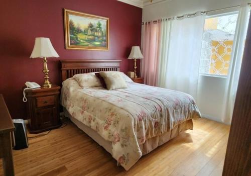 提华纳Sadie's Bed and Breakfast / Hotel的一间卧室配有一张床、两盏灯和一个窗户。