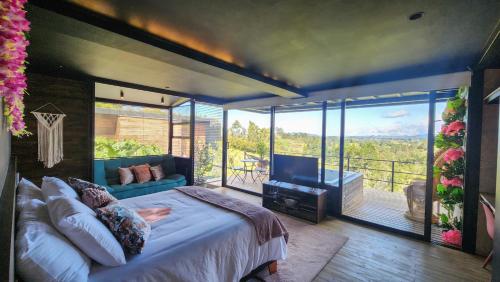 瓜尔内Cumbres Luxury Glamping的一间卧室设有一张床,阳台配有电视。