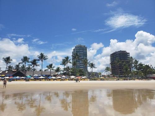 伊列乌斯Village Praia Dourada - Praia dos Milionários的海滩上设有遮阳伞和建筑