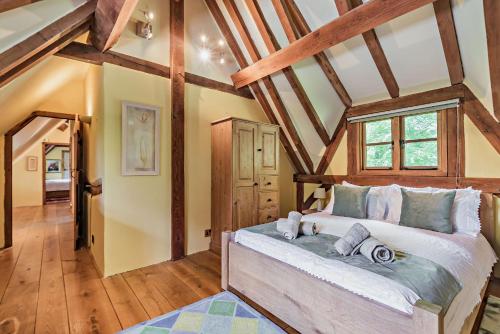 BreamoreThe Cottage, Beautiful New Forest 5 Bedroom Thatched Cottage的一间带一张大床的卧室,位于一个拥有木制天花板的房间