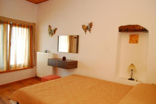 普拉基亚斯斯皮塔基旅馆的卧室配有一张床、镜子和蝴蝶壁