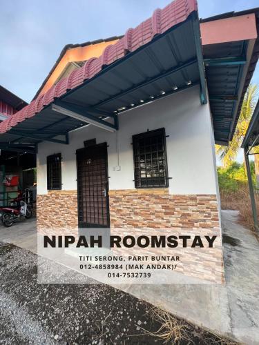 巴力文打NIPAH ROOMSTAY PARIT BUNTAR的一座有标志的建筑,上面有读尼帕路标