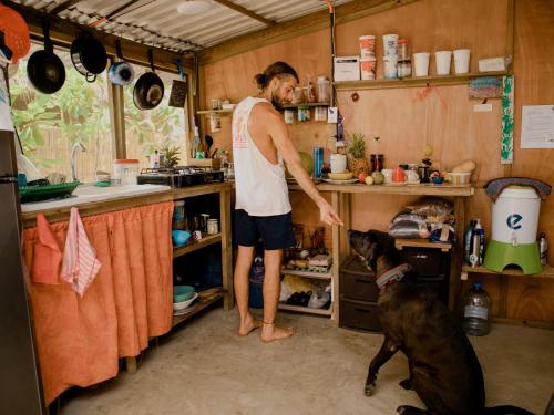 El Paredón Buena VistaCasa Austera的和狗一起站在厨房里的男人