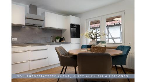 诺特海姆Apartment Leinetal - 3 Zi 70 qm ,Küche, Duschbad, Parkplatz的厨房以及带桌椅的用餐室。