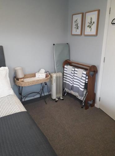 汉密尔顿Rural Gordonton Sleepout的一间卧室配有床、镜子和散热器