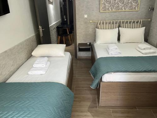 利迈纳里亚Grecian Sea的两张位于酒店客房的床,配有毛巾