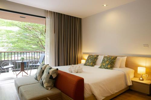 曼谷The Silver Palm Wellness Resort的一间卧室设有一张床和一个阳台