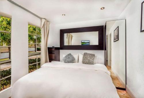 达文波特14 Room DisneyEstate by AmericanVacationliving的卧室配有一张白色大床和镜子