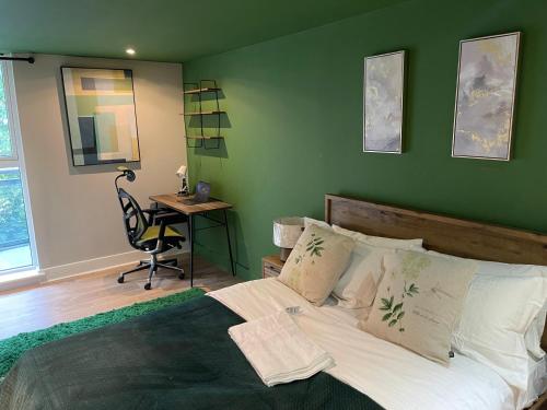 伦敦3BR Apt Near Excel, O2 & City Airport!的一间卧室配有一张带绿色墙壁的床