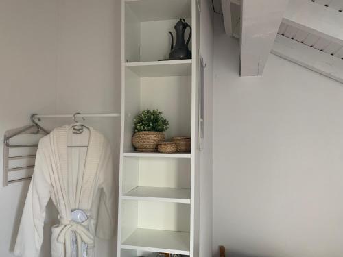 杜塞尔多夫大学安静公寓的白色衣柜,带白色长袍和植物
