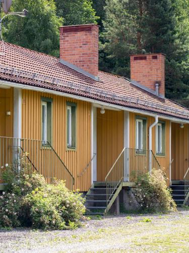 海勒福什Sikfors Gästhus的黄色的房子,有砖烟 ⁇ 和楼梯