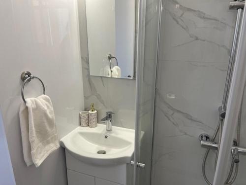 济奇Seaside Studio Zygi的白色的浴室设有水槽和淋浴。