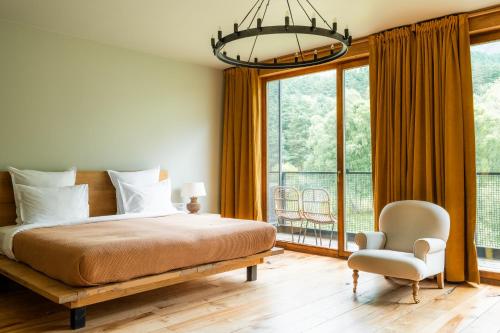 卡兹贝吉卡兹别吉客房酒店的一间卧室配有一张床、一把椅子和一个大窗户