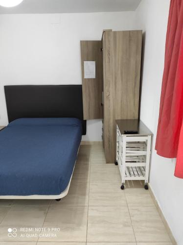 科拉雷侯Alojamientos playa Centro Corralejo 4的小房间,设有床和床头柜