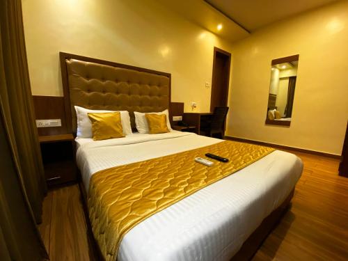 孟买Hotel Pearl's BKC Inn- Near Trade Centre, Visa Consulate的酒店客房,配有一张带黄色床单的大床