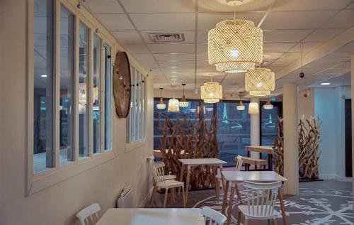 小克维伊UXCO Uppehalls的用餐室配有桌椅和吊灯。