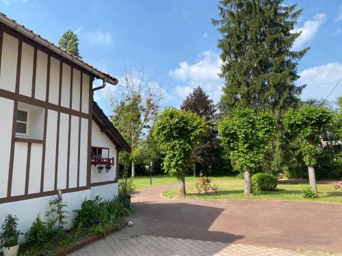 梅里索瓦茨Studio épicéa avec jardin dans charmante propriété的车道旁有树的房子