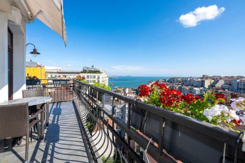 伊斯坦布尔Juno Hotel Taksim的设有一个鲜花阳台,享有城市美景