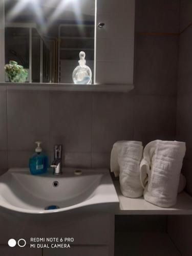 埃雷特里亚Muses apartments的浴室配有盥洗盆、镜子和毛巾