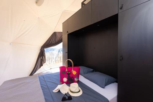 吕奥姆Les Dômes des Gorges的帐篷内的一张床位,上面装有粉红色的袋子