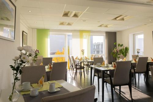 兰河畔马尔堡库斯佩赫尔酒店的用餐室设有桌椅和窗户。