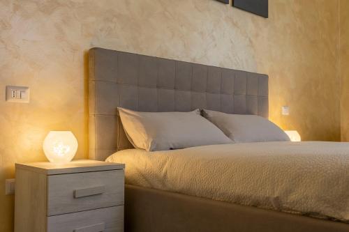 米兰Leader Apartment 2的一间卧室配有一张床和一个带灯的床头柜