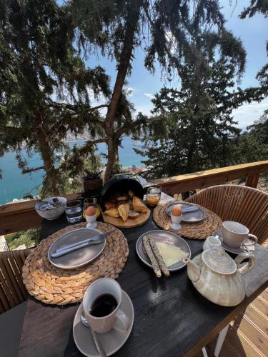 卡利诺岛Spongia Apartments Kalymnos的一张木桌,上面有食物和咖啡