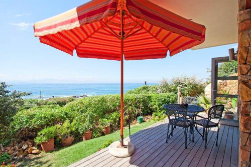 开普敦Vitamin-Sea的露台配有桌椅和遮阳伞