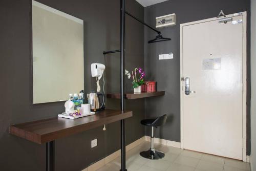马六甲SC Hotel Melaka的浴室配有梳妆台、镜子和椅子