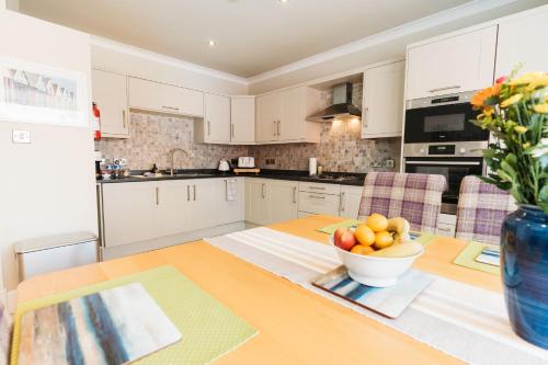 莱瑟姆-圣安妮Birkby Lodge Escape的厨房配有一张桌子,上面放着一碗水果