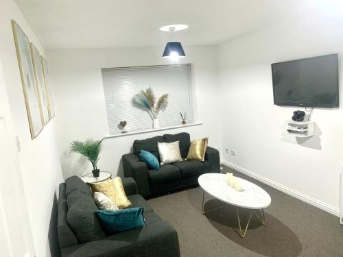 哈罗Flat in London- Modern 2 Bedroom Apartment Harrow near Wembley的客厅配有沙发和桌子