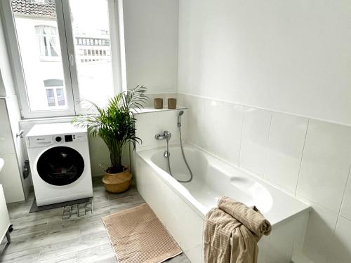 汉诺威Design Apartment - Parking - Kingsize-Bett - 2x Bad - Zentrum的带浴缸和洗衣机的白色浴室