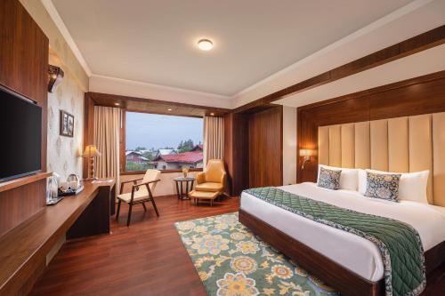 斯利那加WelcomHeritage Grand, Srinagar的酒店客房,配有床和电视