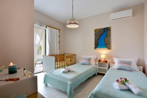 斯达林Ariadni Sidari Beach House的一间卧室设有两张床和一张带蜡烛的桌子。