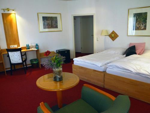 翁纳纳克特瓦斯特尔酒店的酒店客房带两张床和一张桌子以及椅子。