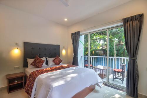 巴加Amazing 2BHK Apartment Near Baga Beach By Stay Over Home的一间卧室设有一张床和一个阳台